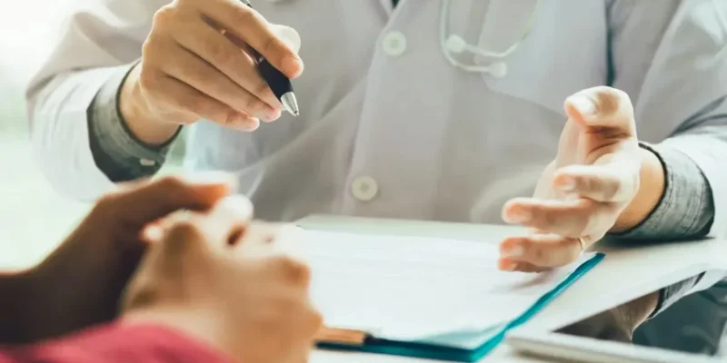 Paciente lendo documentos hospitalares para entender seus direitos após mau atendimento médico.